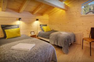 a bedroom with two beds in a wooden cabin at Chalet Elomaz - OVO Network in Saint-Jean-de-Sixt