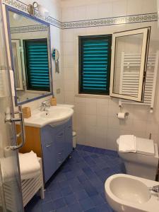 a bathroom with a sink and a toilet and a mirror at Le Esperidi House in Ravello