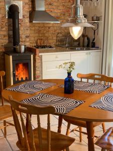 a kitchen with a wooden table with chairs and a fireplace at Puhkemaja saunaga Villa Hanson in Noarootsi +24 photos