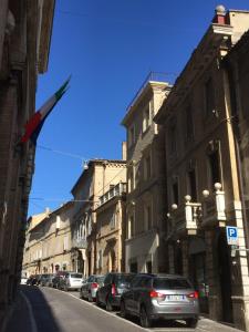 a row of cars parked on a street with buildings at B&B Porta Santa Lucia - Appartamento in Fermo