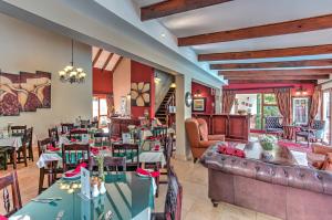um restaurante com sofás, mesas e cadeiras em Sunninghill Guest Lodges em Joanesburgo