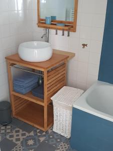 La salle de bains est pourvue d'un lavabo, d'un miroir et d'une baignoire. dans l'établissement Gîte "Près de l'Eau", avec parking ferme, à La Roche-sur-Yon