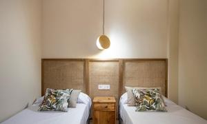 1 dormitorio con 2 camas con sábanas blancas en Terraza Playa de Cádiz 2 Ha Apartment en Cádiz
