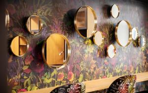 Un mucchio di specchi su un muro in bagno. di Andersen Boutique Hotel a Copenaghen