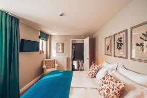 a hotel room with a bed and a chair at Les Maisons d'Edouard Numéro 116 in Spa