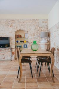 uma sala de jantar com uma mesa de madeira e cadeiras em Conte Orsini Apartment em Conversano