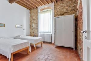 Un dormitorio con dos camas y una pared de ladrillo. en Villa Galgani, en Lucca