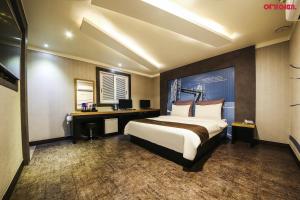 坡州的住宿－洛爾斯酒店，酒店客房设有一张大床和一张书桌。