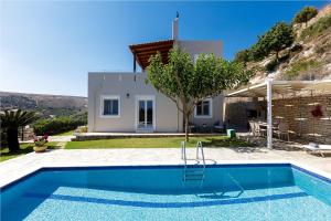 a villa with a swimming pool in front of a house at Agios Antonios Villas in Agia Triada