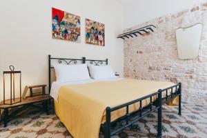 una camera con letto e muro di mattoni di Conte Orsini Apartment a Conversano