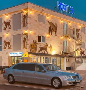 um carro estacionado em frente a um hotel em Hotel Babylon am Europa-Park em Ringsheim