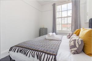 1 dormitorio con cama y ventana en Guest Homes - Montpellier Villa Apartment, en Cheltenham