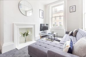 sala de estar con sofá y TV en Guest Homes - Montpellier Villa Apartment, en Cheltenham