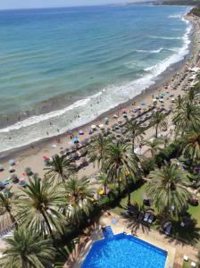 - une vue aérienne sur une plage bordée de palmiers et une piscine dans l'établissement Skol 913A by Completely Marbella, à Marbella