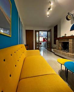 a yellow couch in a living room with a fireplace at La casa colorata in Città di Castello