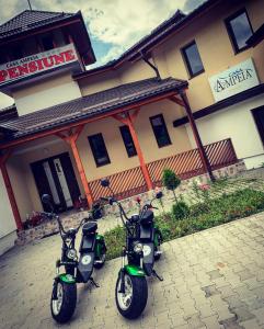 due scooter parcheggiati di fronte a un edificio di Pensiune Casa Ampeia a Alba Iulia