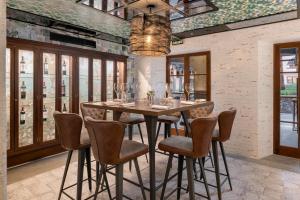 a dining room with a wooden table and chairs at Santa Catalina, a Royal Hideaway Hotel in Las Palmas de Gran Canaria