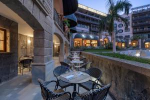 an outdoor patio with tables and chairs in a building at Santa Catalina, a Royal Hideaway Hotel in Las Palmas de Gran Canaria +21 photos