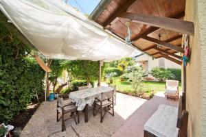 een patio met een tafel en stoelen onder een pergola bij La casina del Mare in Marina di Massa