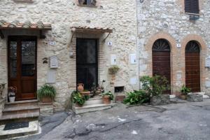 un bâtiment en pierre avec des portes et des plantes en pot sur les marches. dans l'établissement LA PIETRA UMBRA di Benedetta & Bros, à Porchiano