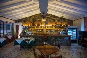 un ristorante con tavoli e un bar in una stanza di Aldeia da Fonte Hotel a Lajes do Pico