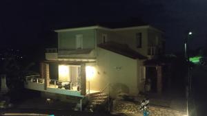 una casa con balcón por la noche en Kassandra Villa Nafplio, en Asíni