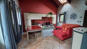 sala de estar con sofá rojo y mesa en Le Petit Rascard, en Châtillon