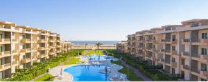 an aerial view of a resort with a pool and the ocean at مارينا دلتا in ‘Izbat Abū Sulayman