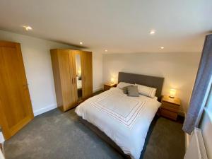 a bedroom with a large white bed and two lamps at Blackberry Cottage in Sutton Valence
