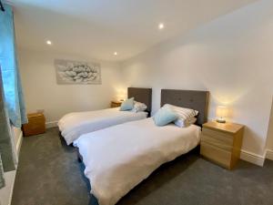 2 camas en una habitación con 2 lámparas en Blackberry Cottage en Sutton Valence