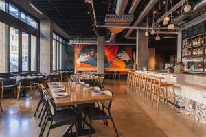 a restaurant with wooden tables and chairs and a bar at Hyatt Centric Downtown Portland in Portland