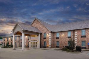 a large brick building with a large entrance at Days Inn & Suites by Wyndham Florence/Jackson Area in Florence