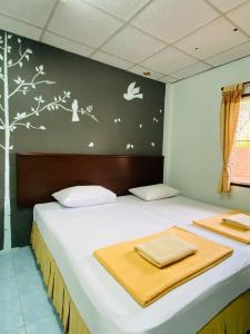 1 dormitorio con 1 cama con pájaros en la pared en Phang Nga Guesthouse en Phangnga