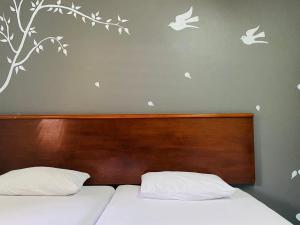 a bedroom with two beds with birds on the wall at Phang Nga Guesthouse in Phangnga