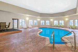 een zwembad in een grote kamer met stoelen en tafels bij La Quinta by Wyndham Oklahoma City -Yukon in Yukon