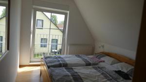 une chambre avec un lit et une grande fenêtre dans l'établissement Wellenberg, à Breege