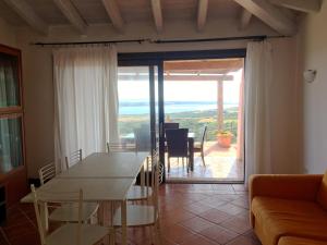 a dining room with a table and a view of the ocean at Villa Aura in Stintino