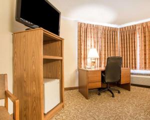a living room with a tv and a chair at Econo Lodge Inn & Suites Stevens Point in Stevens Point