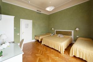 a bedroom with a bed, desk, chair and a lamp at Hotel Gennarino in Livorno