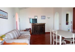 een woonkamer met een bank en een tafel bij Villa Aura in Stintino