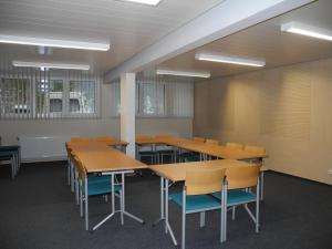 ein Klassenzimmer mit Holztischen und -stühlen in der Unterkunft Jutel Obertraun in Obertraun