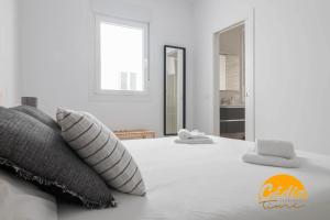 - une chambre avec un grand lit blanc et des oreillers dans l'établissement Casa del Fotografo by Cadiz Time, à Cadix
