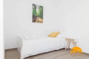 - une chambre avec un lit blanc et une photo sur le mur dans l'établissement Casa del Fotografo by Cadiz Time, à Cadix