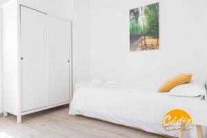 - une chambre avec des placards blancs et un lit dans l'établissement Casa del Fotografo by Cadiz Time, à Cadix