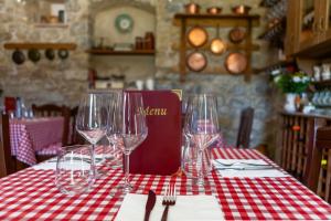 uma mesa com copos de vinho numa toalha de mesa vermelha e branca em Il poggio degli antichi sapori em Paternopoli