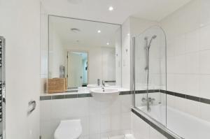 a bathroom with a sink and a shower and a toilet at Perfectly Located Beautiful Ensuite and Gym in London