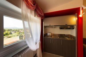 a kitchen with a window with a view of a city at Residence Le Betulle Executive in Caselette