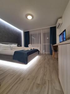 a hotel room with a bed and a flat screen tv at Turquoise Boutique in Mamaia Nord
