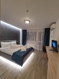 a bedroom with a bed and a desk and a television at Turquoise Boutique Mamaia Nord in Mamaia Sat/Năvodari
