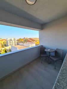 a room with a table and chairs and a large window at Turquoise Boutique Mamaia Nord in Mamaia Sat/Năvodari +67 photos